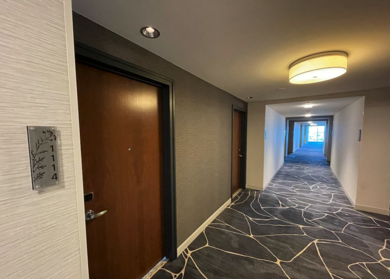 a hallway with a door and a tile floor